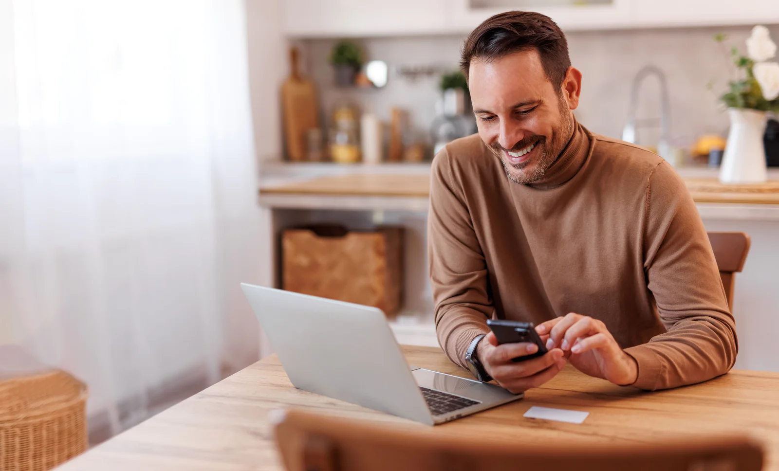 thumbnail-trend-2.png Portrait of smiling mid adult man with credit card using mobile phone and laptop on dining table at home