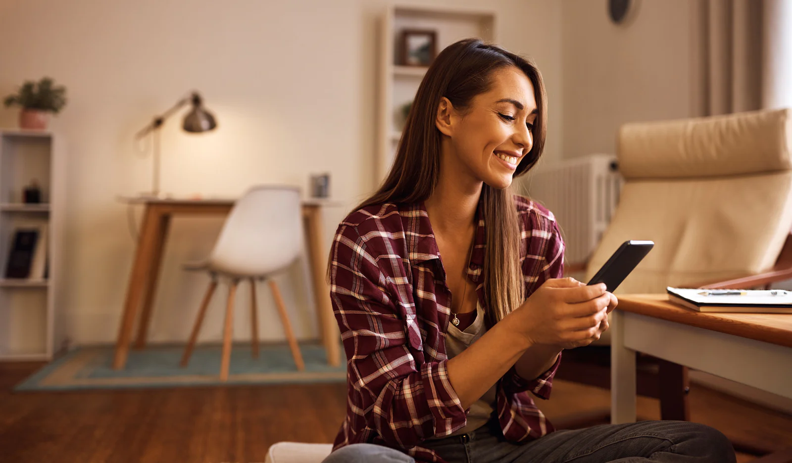 AI must benefit businesses and consumers Woman smiling at her phone.