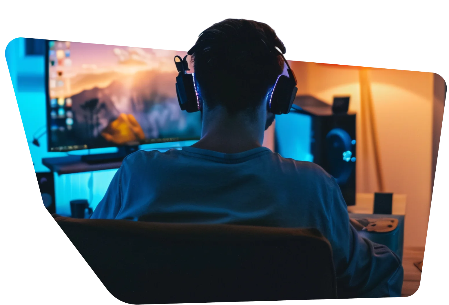 Man at computer screen Person with headphones playing on a computer at a gaming setup, screen displaying a scenic background.