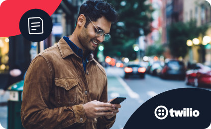 Man in brown jacket using smartphone on a city street with blurred cars in the background