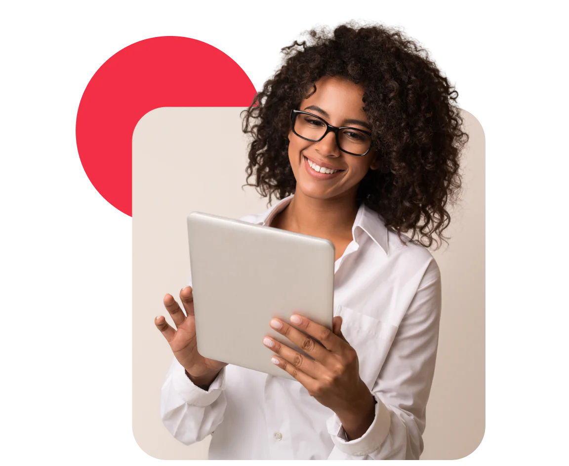 Smiling woman with curly hair and glasses using a tablet