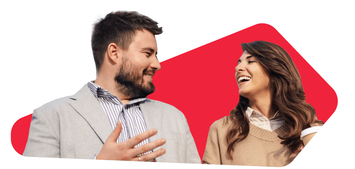 Two people, a man and a woman, smiling and talking against a red background. Two people, a man and a woman, smiling and talking against a red background.