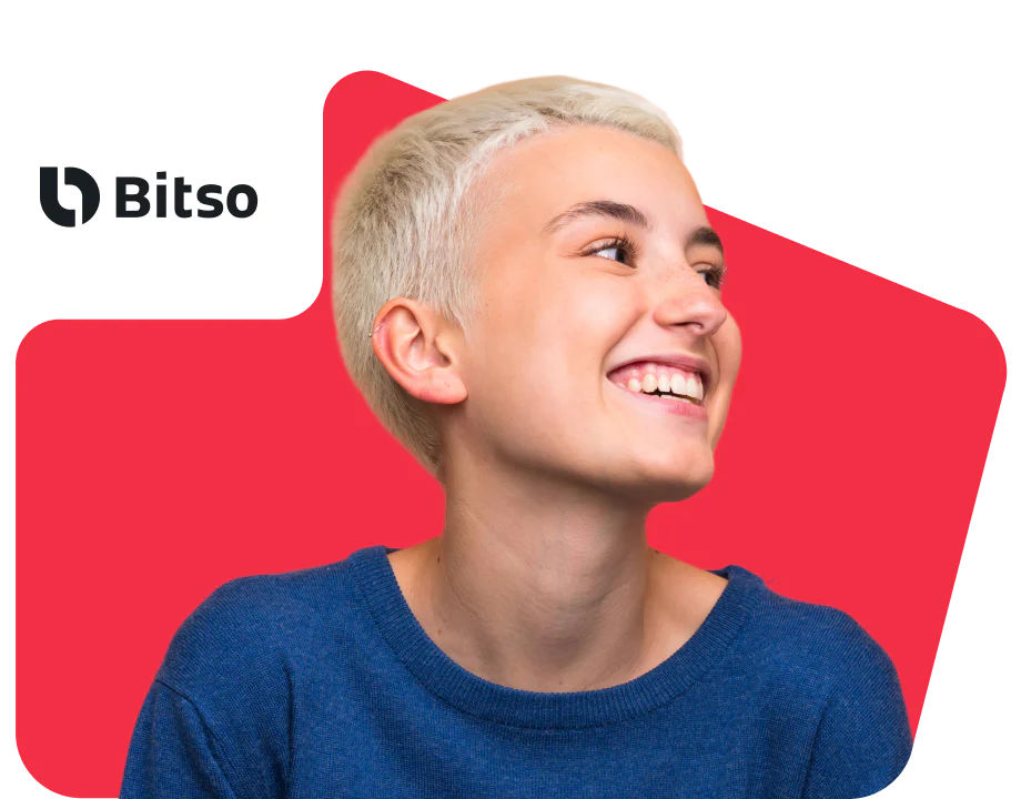 Bitso secure transactions using Twilio Verify Woman in blue blazer smiling at her smartphone on a sunny day.