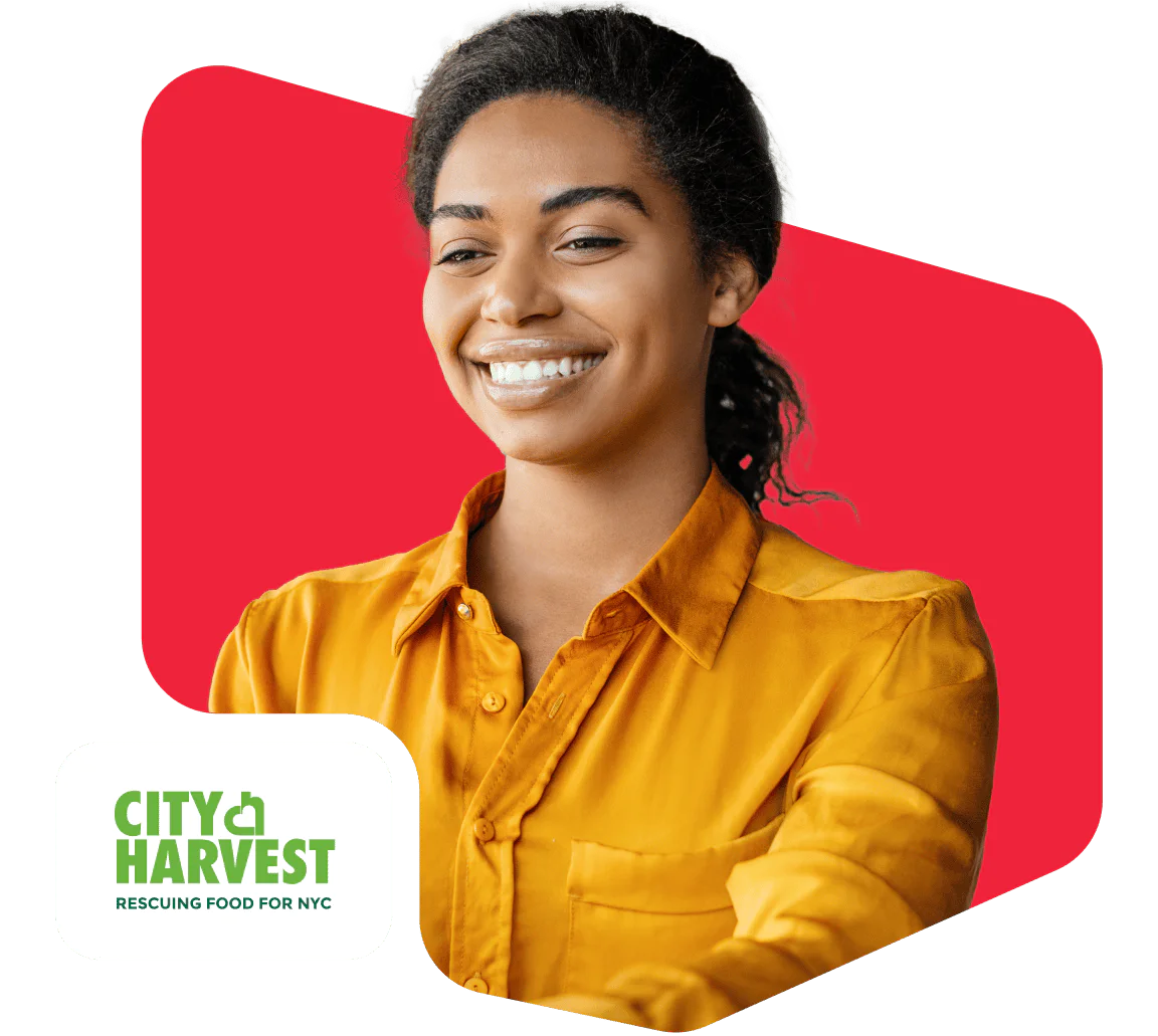 Smiling Volunteer for City Harvest NYC Person smiling in a yellow shirt with City Harvest NYC logo
